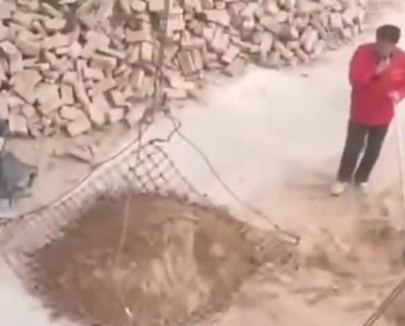 Man shovels pile of dirt onto net…it falls through the holes.