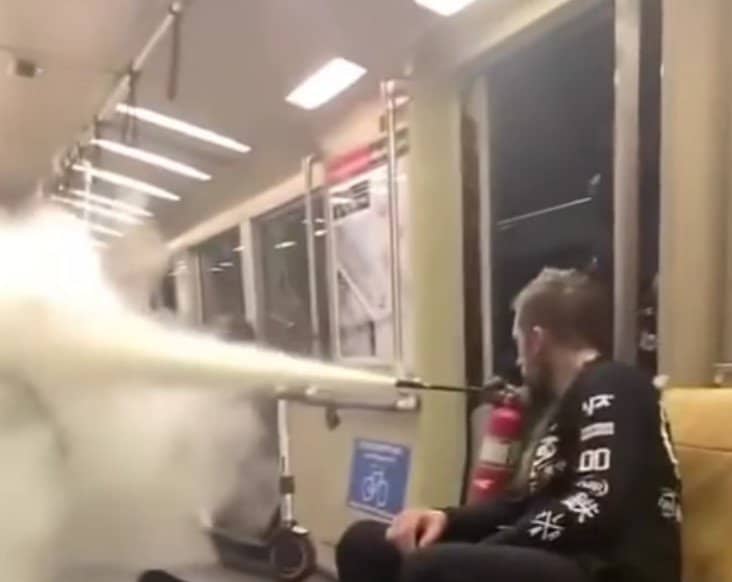 Migrant spreads his cool culture by spraying fire extinguisher into subway train car to demonstrate fire-safety education.